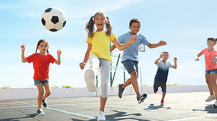 Behind The Scenes: Tween Council 2023 - Sports Girls and boys play football happily on an outdoor pitch.