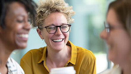 Wie ticken Lehrkräfte? Zwei Lehrerinnen lachen miteinander und halten Kaffeebecher in der Hand. Das Bild steht symbolisch dafür, dass Lehrkräfte keine homogene Zielgruppe sind. Bildungsanbieter, die alle Lehrkräfte gleich ansprechen, verpassen die Chance, sie als Multiplikator:innen für ihre Angebote zu gewinnen.
