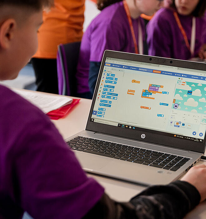 Junge sitzt vor Laptop 