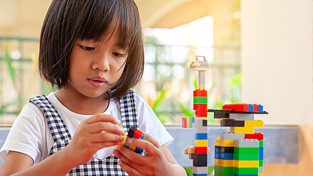 Are Toys Recession Resilient? Little girl playing peacefully with "Lego"-building blocks.