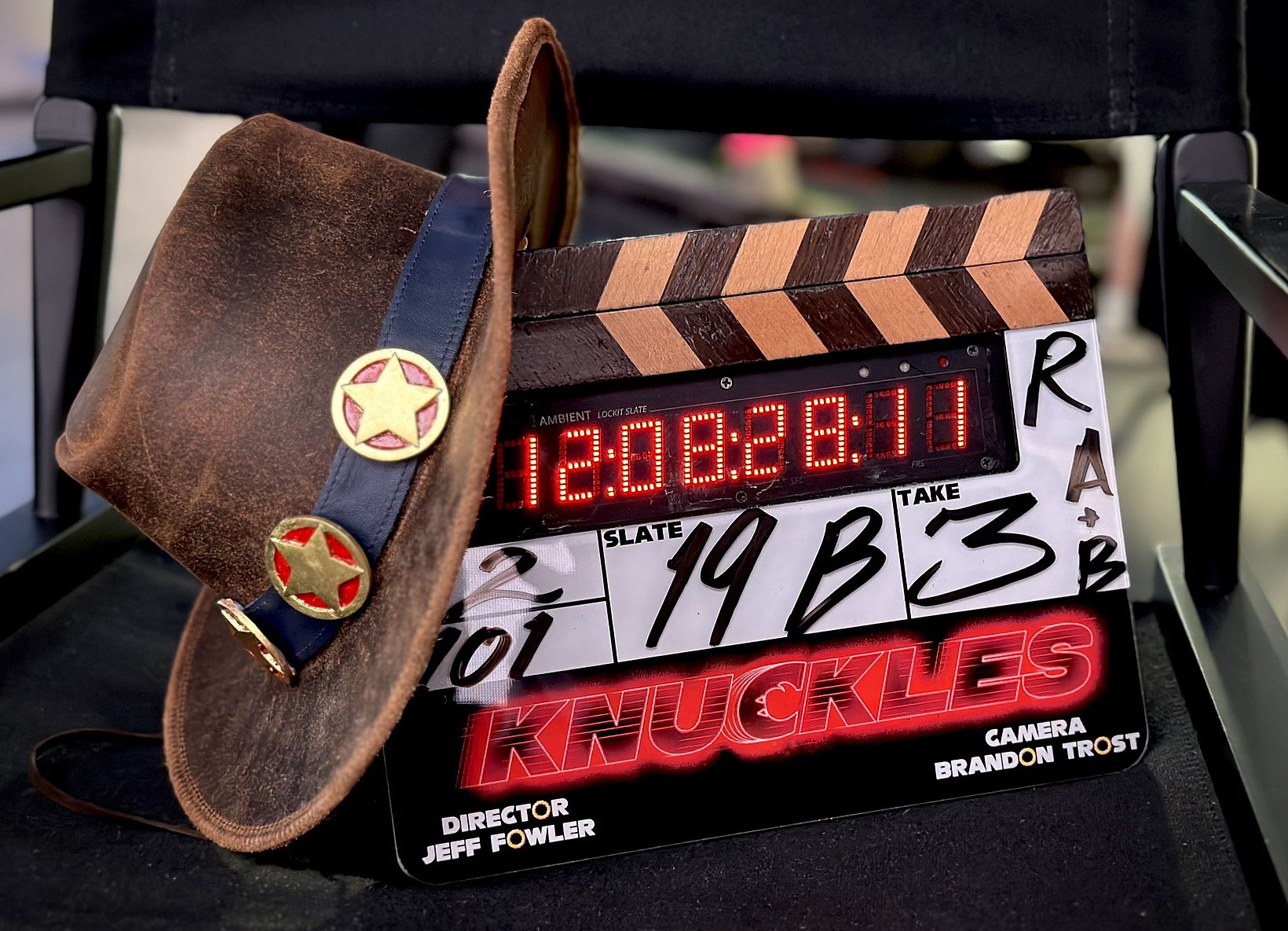 Clapperboard with "Knuckles" title and director Jeff Fowler's name, adorned with a cowboy hat featuring star badges, indicating an ongoing film shoot.