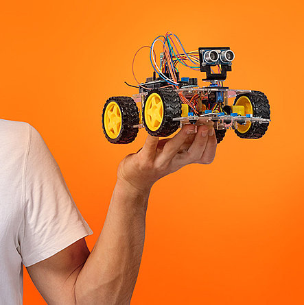 Hand hält ein elektrisches Modellauto.