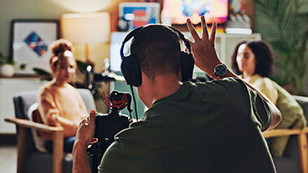 Take 1 mit unserem Head of Video Steffen! Kameramann und Schauspieler sind an einem Filmset und drehen eine Szene.