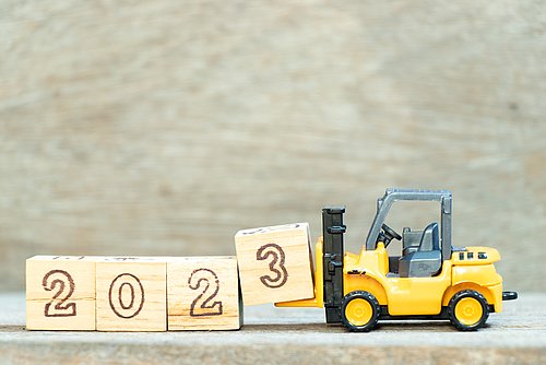 Forklift lifts a block with the number "3" to complete the year 2023.