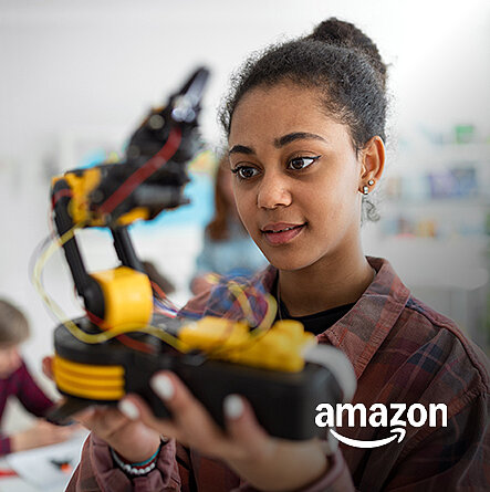 Junges Mädchen hält einen schwarz-gelben Roboter in der Hand