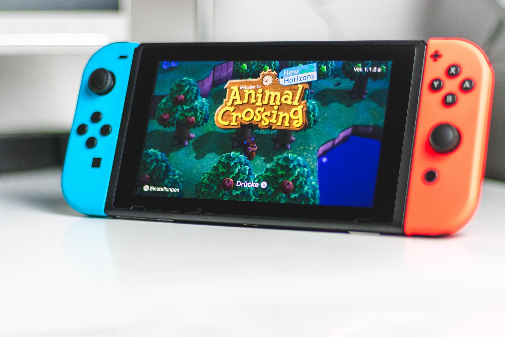 A Nintendo Switch is on a table and the game "Animal Crossing" can be seen on the screen.