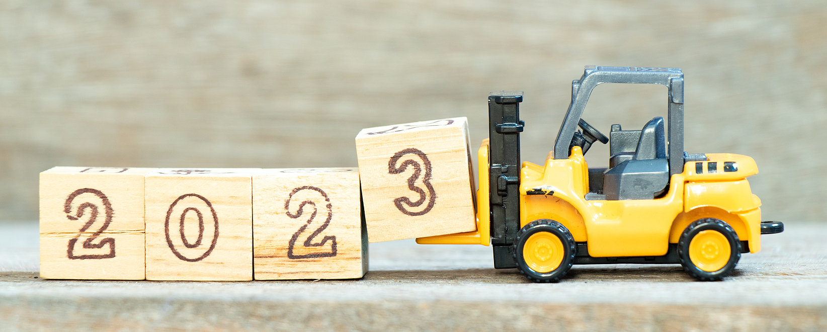 Forklift lifts a block with the number "3" to complete the year 2023.