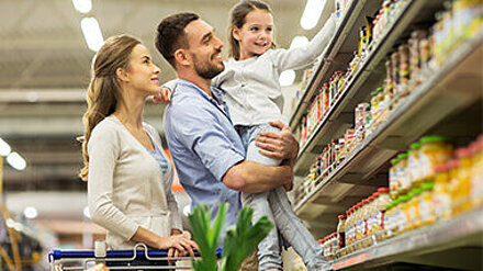 Effiziente Ernährung? Vater und Mutter sind mit ihrer Tochter im Supermarkt einkaufen.