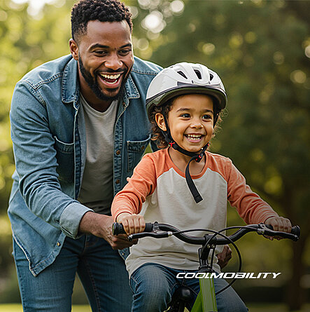 Vater hilft seinem Kind beim Fahrrad fahren. Beide lachen.