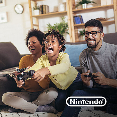 Eltern spielen mit ihrem Sohn ein Videospiel und lachen