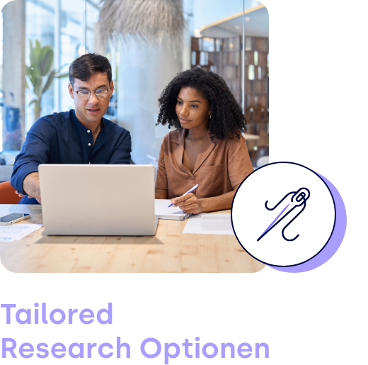 Zwei Personen sehen auf einen Laptop und unterhalten sich angeregt.