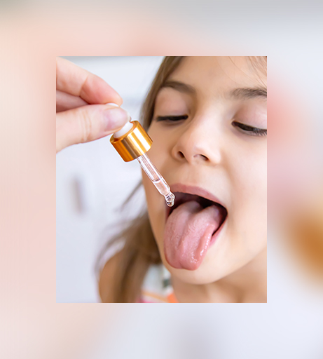Mädchen erhält Supplement-Tropfen mit Pipette – Studie zu Nahrungsergänzung für Kinder