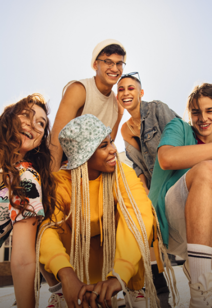 Ein Gruppe Teeanger posiert lachend im Freien.