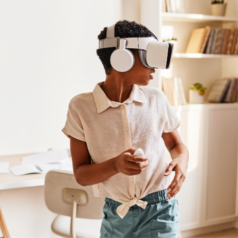 Kind trägt eine VR-Brille und läuft dabei mit Blick über seine Schulter durch einen Raum.