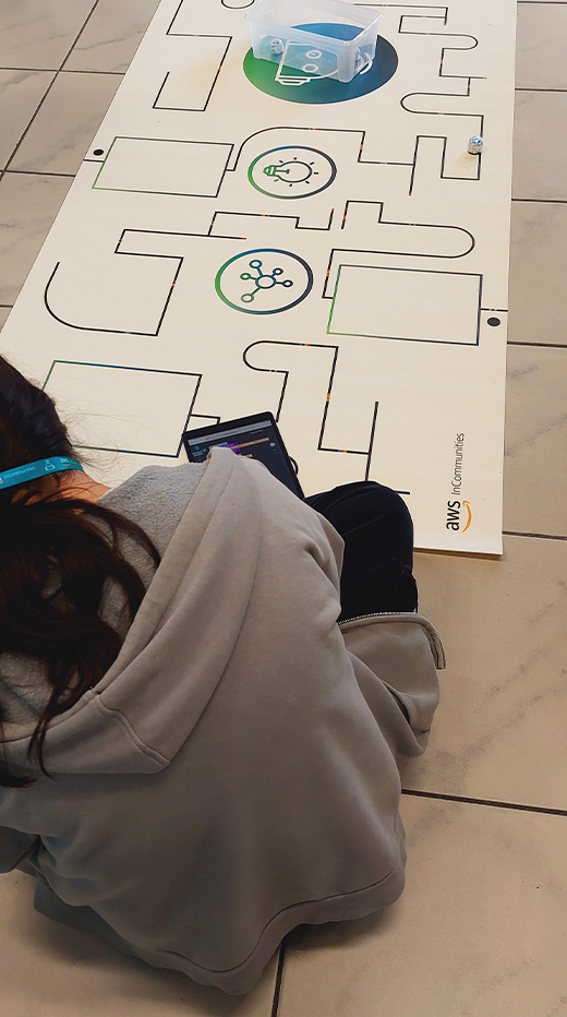 Ein Mädchen sitzt auf dem Boden und schauen auf eine Zeichnung, die darauf liegt.