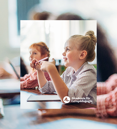 Kinder sitzen an einem Tisch mit Stiften in der Hand und hören aufmerksam zu