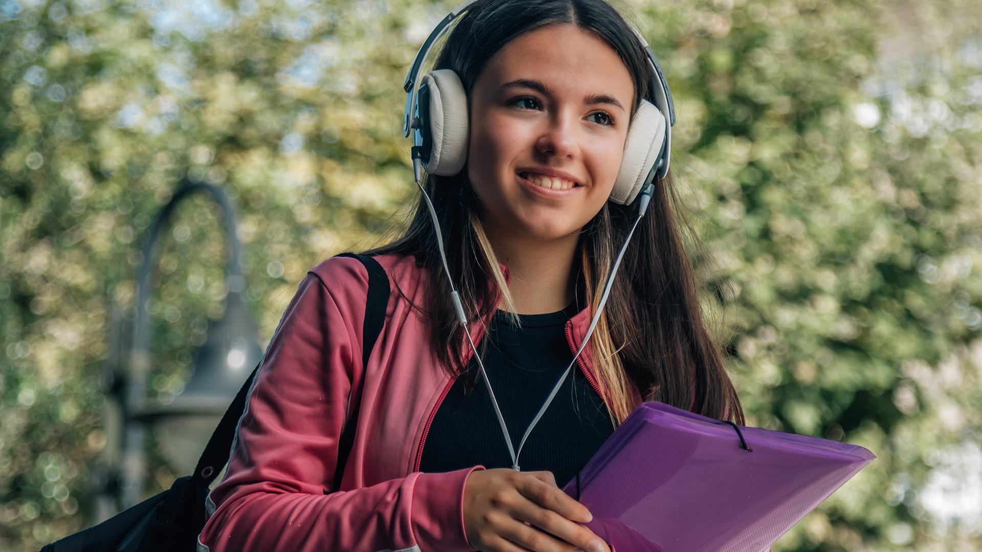 Junges Mädchen mit langen dunklen Haaren und Kopfhörern auf