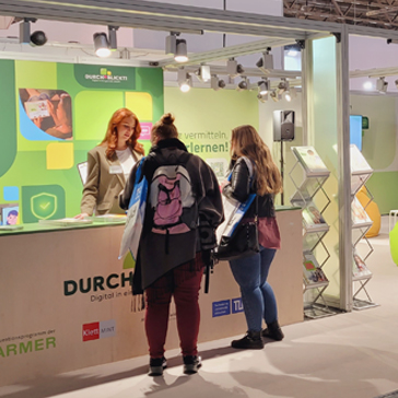 Menschen vor dem Barmer Messestand auf der didacta