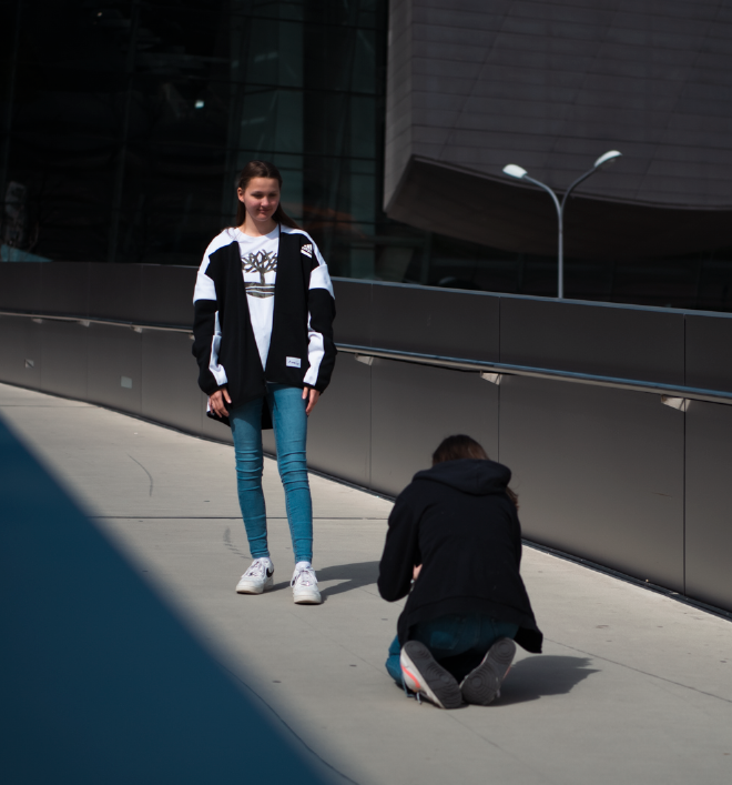 Ein Mädchen kniet vor einem andern Mädchen auf dem Boden