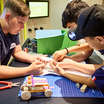 Kinder tüfteln an einem Tisch