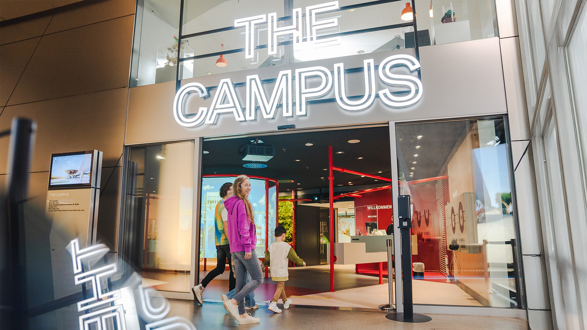 Kinder laufen auf einen Eingang mit der Aufschrift The Campus zu