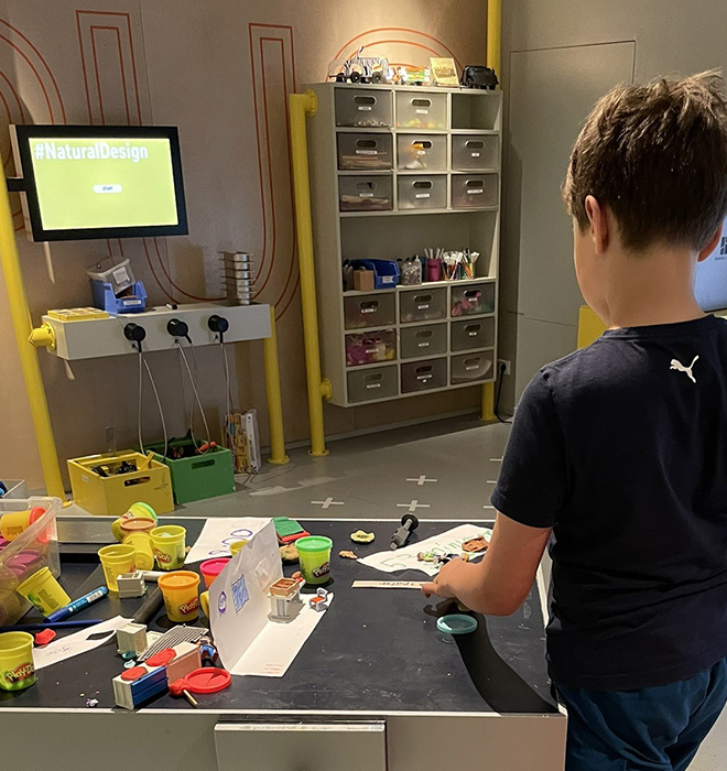 Kind am Tisch bastelt an etwas