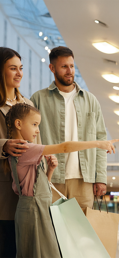 Familie in einer Shopping Mall vor einem Schaufenster