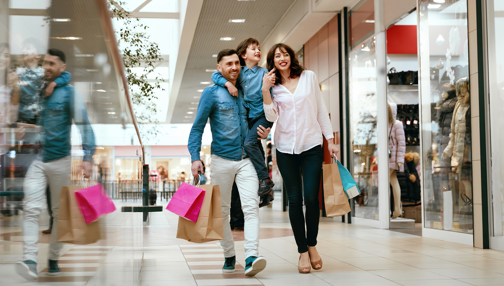 Familie mit Einkaufstüten in Shopping Mall