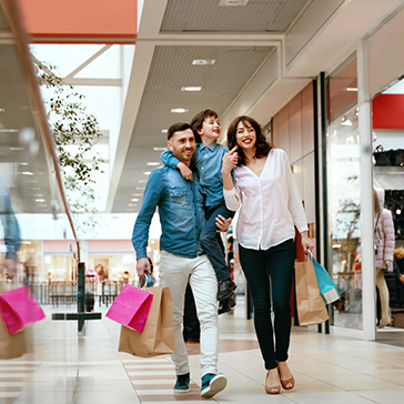 Familie mit Einkaufstüten in Shopping Mall