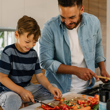 Vater kocht gemeinsam mit seinem Sohn in der Küche