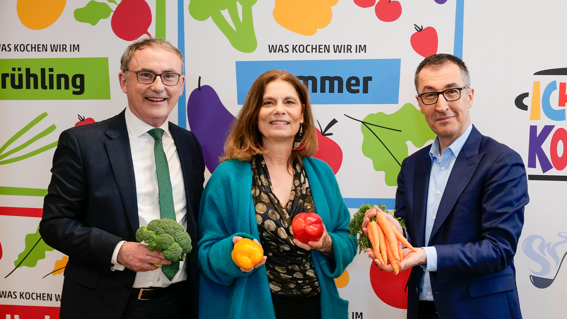 Zwei Männer und einer Frau mittleren Alters nebeneinanderstehend