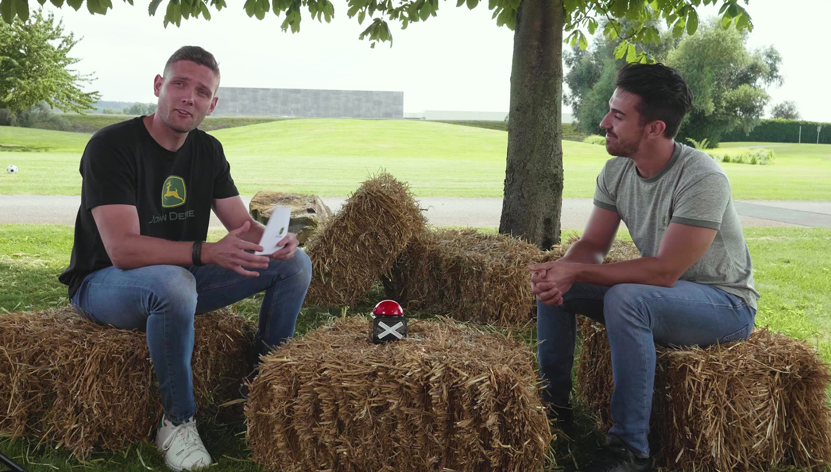 Zwei Männer auf Strohballen sitzend unterhalten sich