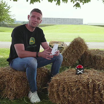 Mann sitzt auf Strohballen