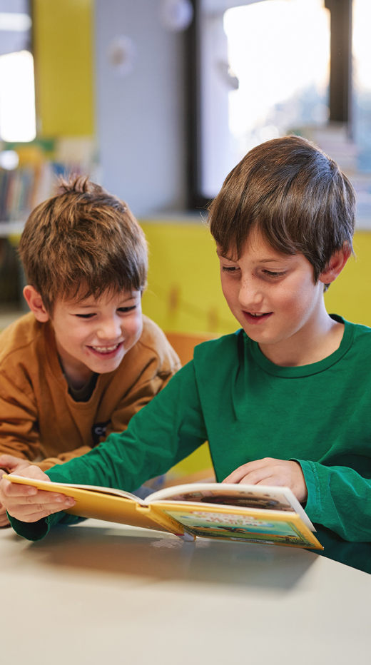 Zwei Jungen mit Buch in der Schule