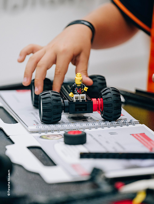 Fahrzeug aus Lego was von einer Kinderhand gehalten wird