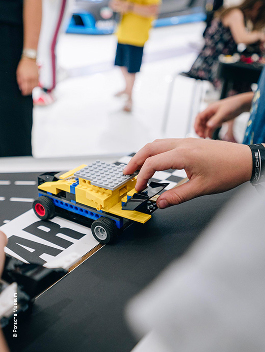 Fahrzeug aus Lego was von einer Kinderhand gehalten wird