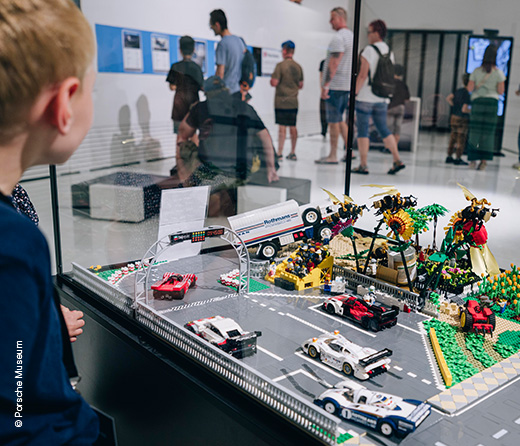 Kind steht vor Miniatur-Landschaft aus Lego