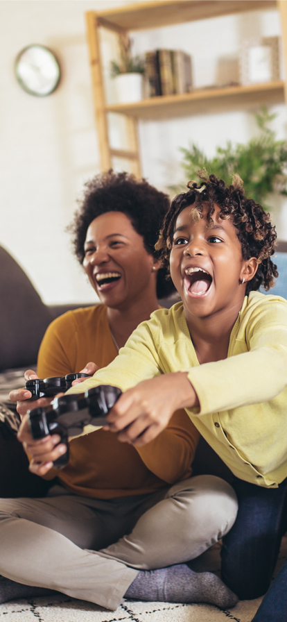 Eltern spielen mit ihrem Sohn ein Videospiel und lachen