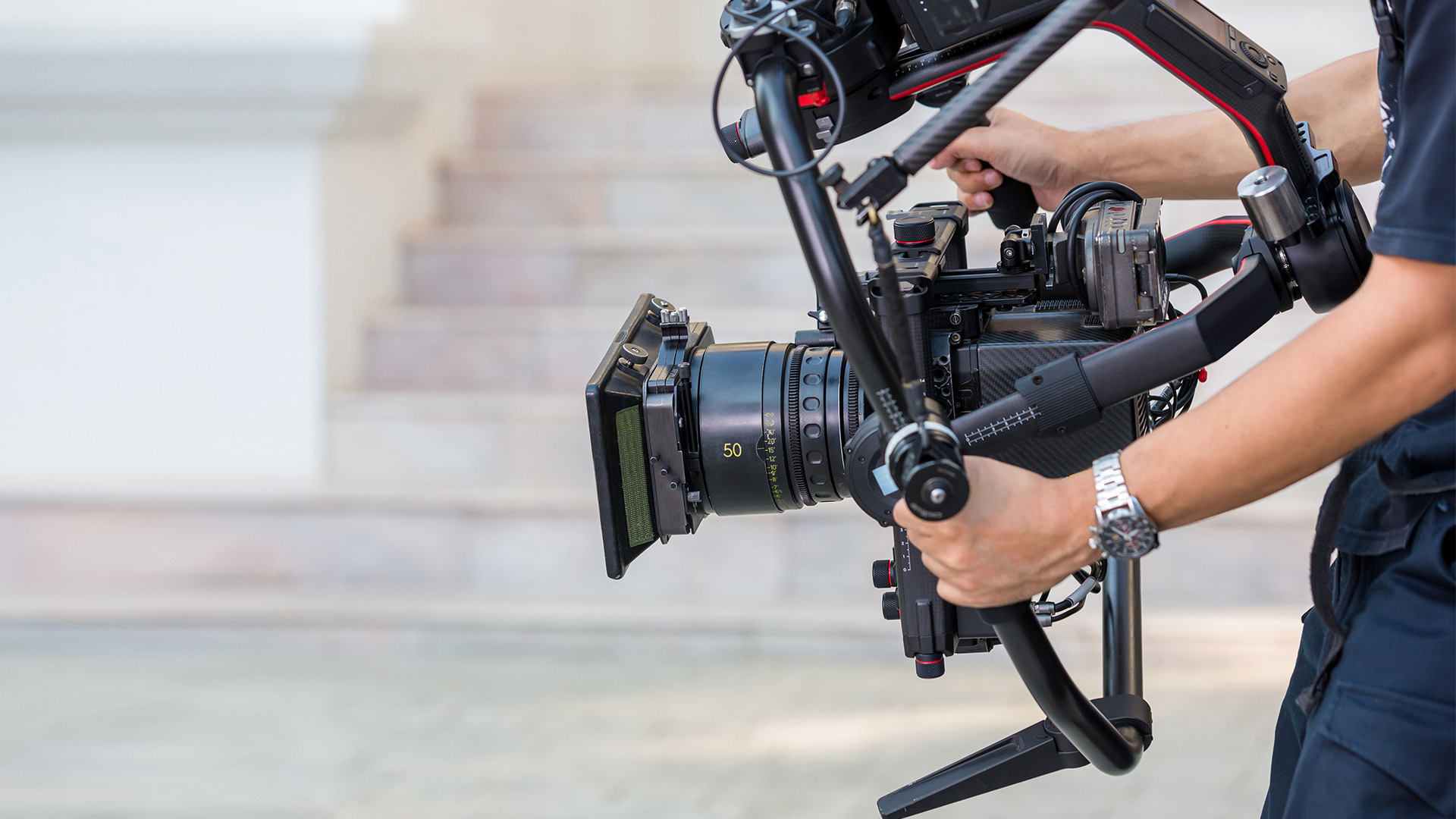 Professionelle Filmkamera die von einer Person gehalten wird