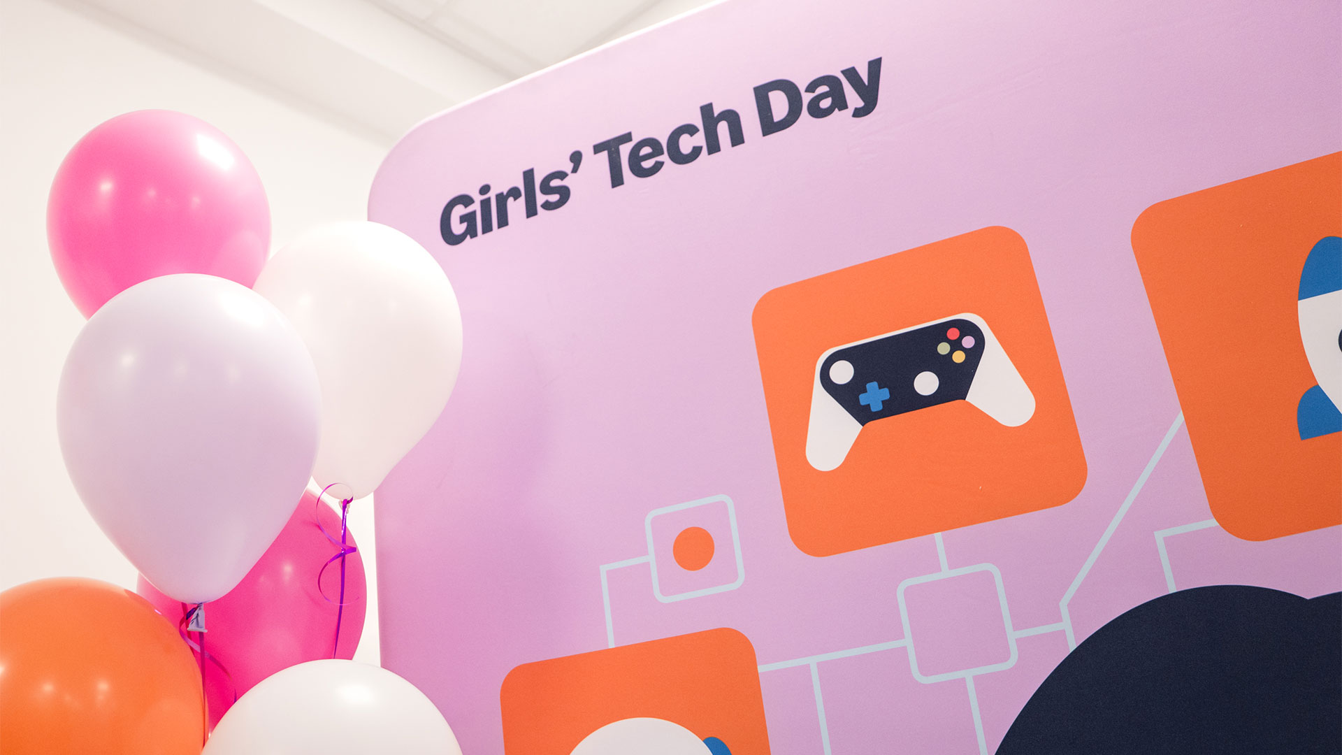 Rosa Schild mit der Beschriftung Girls Tech Day und weiße Luftballons auf der Seite