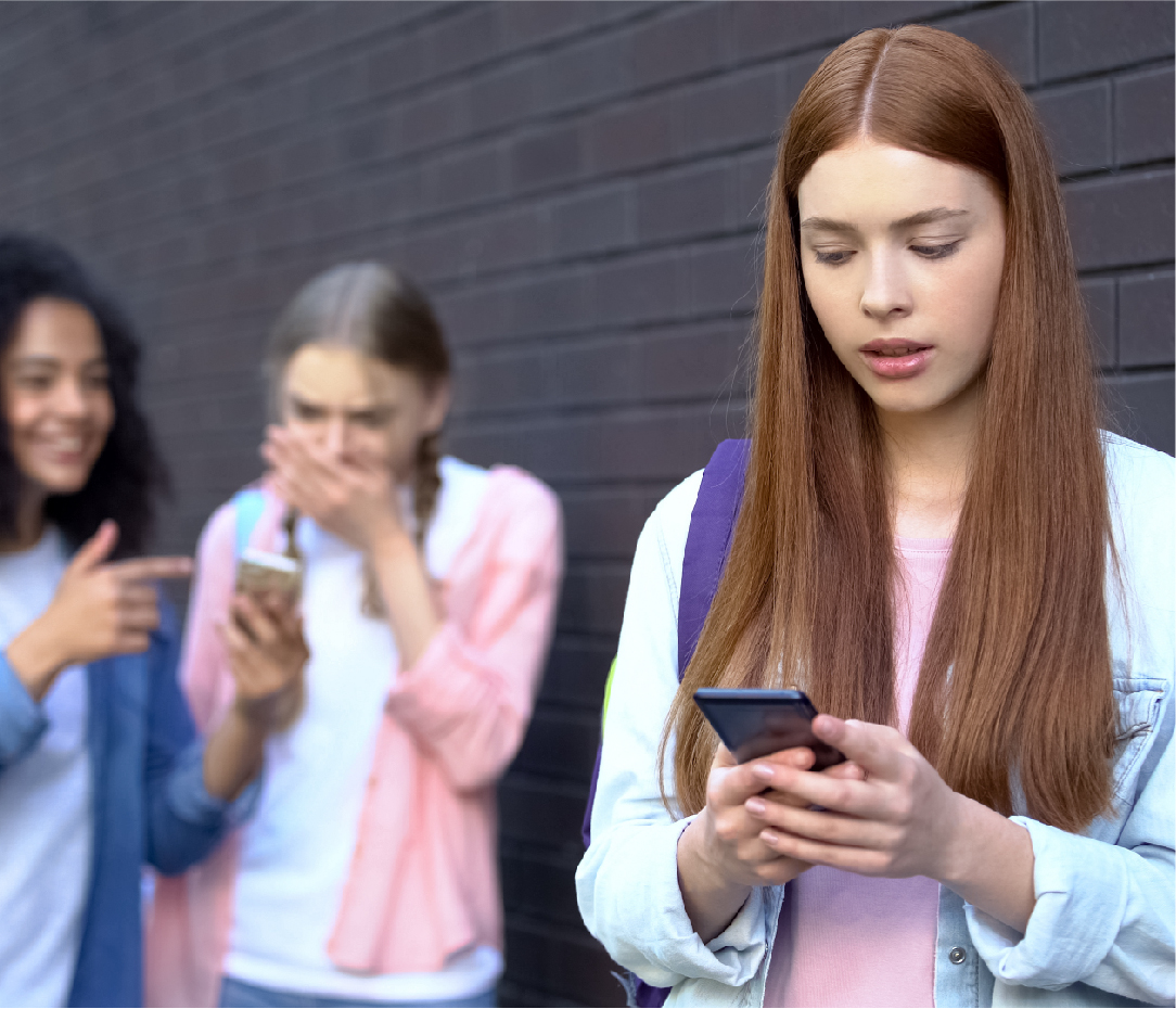 Schülerinnen konsumieren soziale Medien auf ihren Smartphones und schauen schockiert auf ihre Handys.