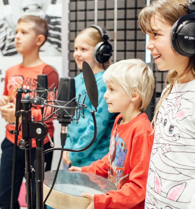 Schoolchildren happily record an audio book.