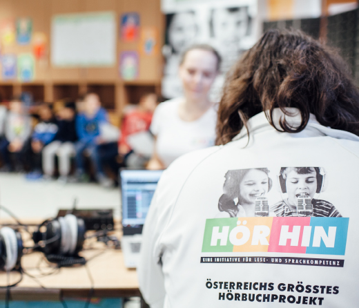 Educational specialist holds a lesson. Written on the T-shirt: "HÖR HIN - An initiative for reading and language skills - Austria's largest audio book project"