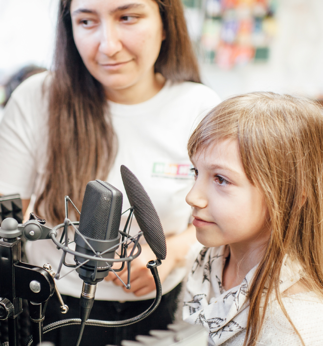 Schoolchild listens to an audio book, guided by a pedagogical specialist