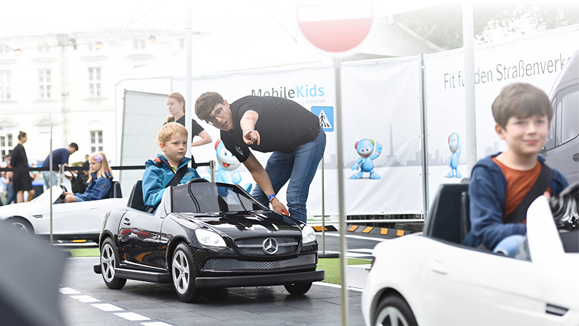 Kinder fahren Spielautos im Rahmen von MobileKids