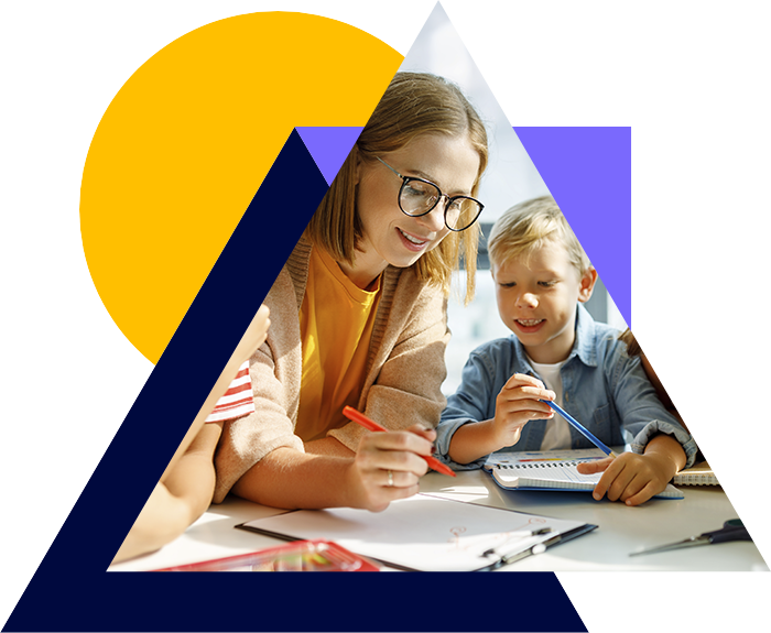  A teacher with glasses is helping a young boy with a drawing, while he holds a pencil and smiles. The scene highlights a positive learning environment and creativity.