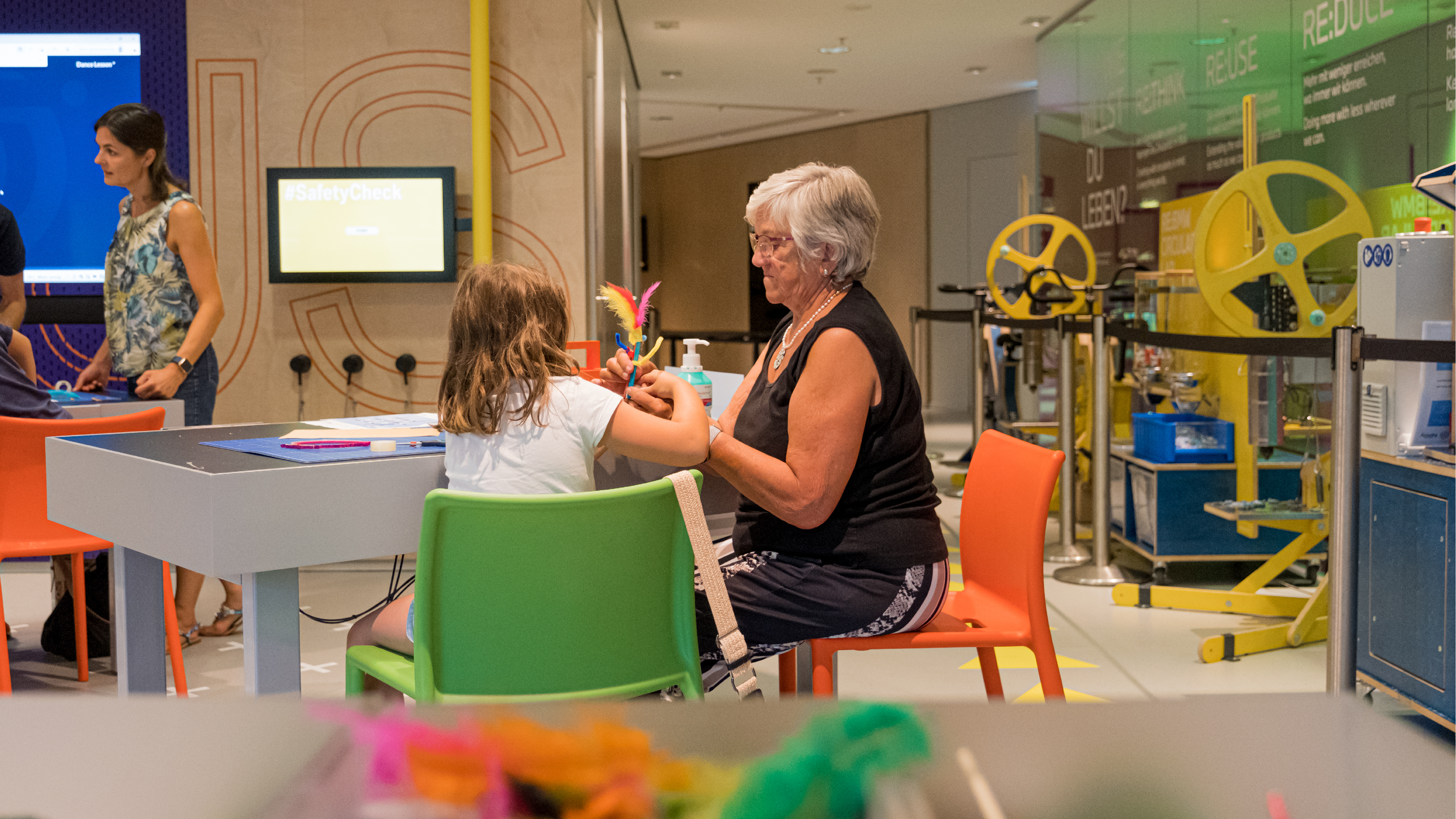 Grandmother helps her granddaughter at the BMW The Campus Workshop.