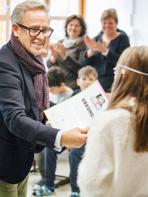 Schoolchild receives a certificate of participation from HÖR HIN.