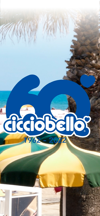 Spiaggia con ombrelloni sullo sfondo e il logo di Cicciobello con il numero dell'anniversario "60" e 1962-2022