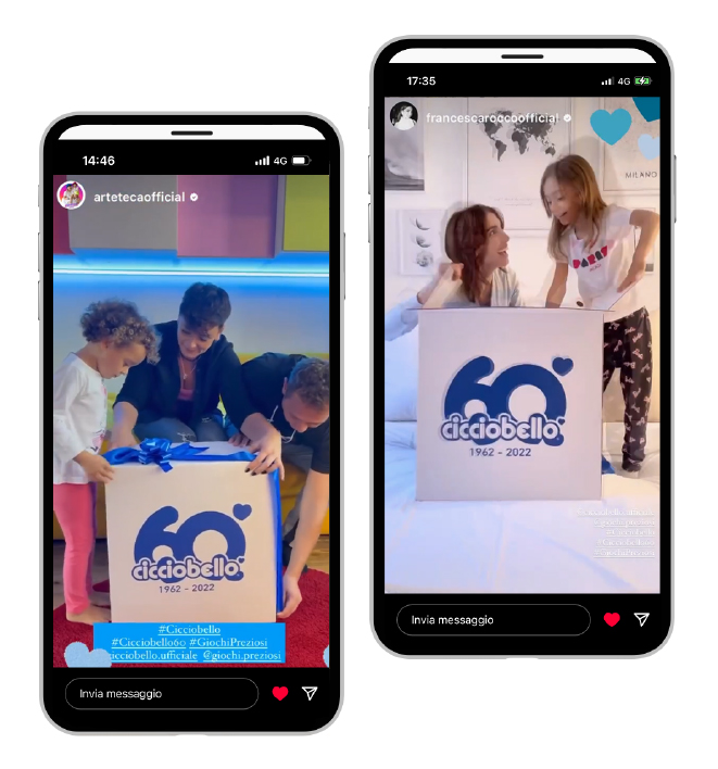 Mock-up di un telefono cellulare e sullo schermo genitori con bambini che disfano una grande scatola di Cicciobello da ricorrenza.